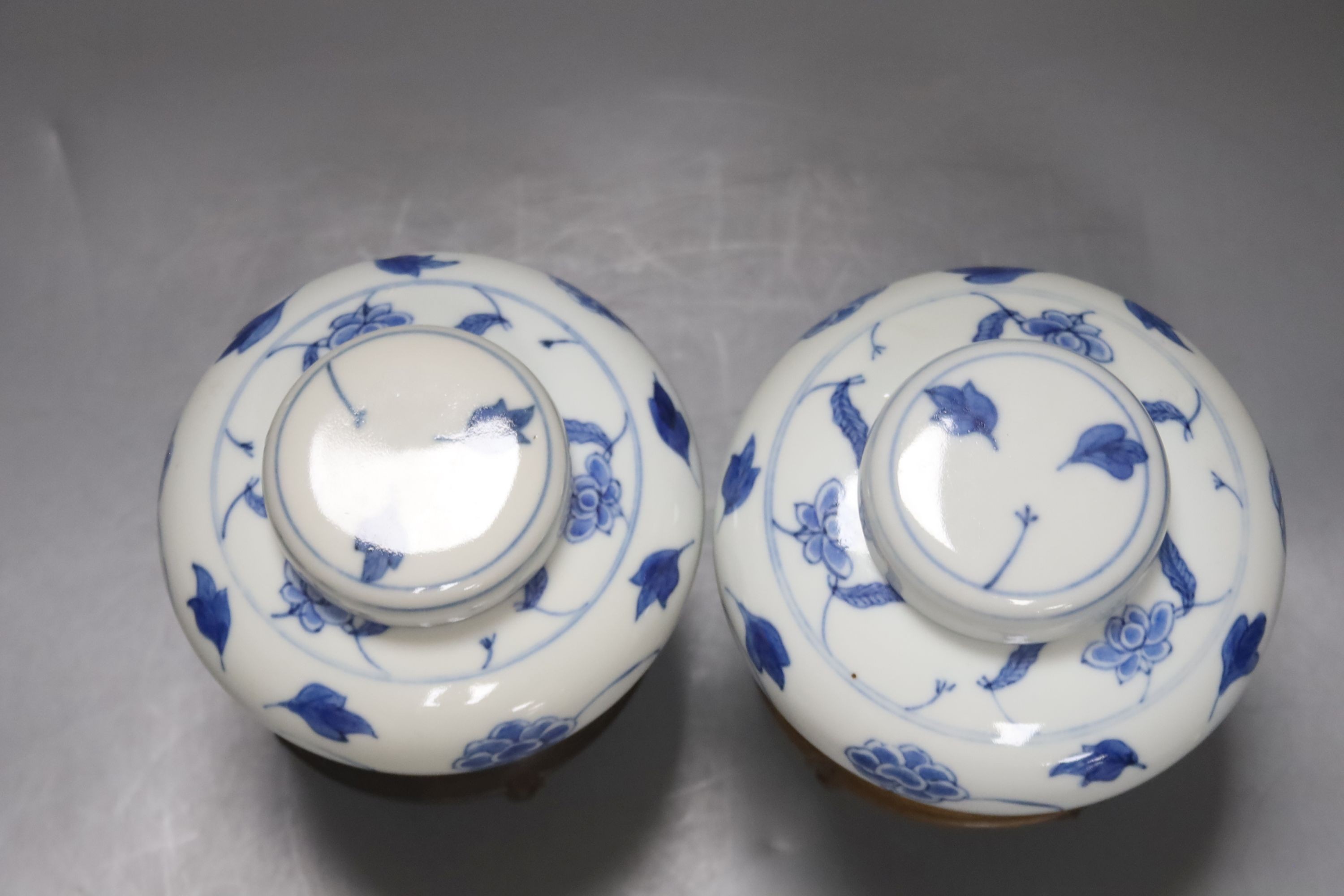 A pair of Chinese blue and white jars and covers, 6.5cm, on wood stands, a Chinese blue and white bowl and two small enamelled wine cups